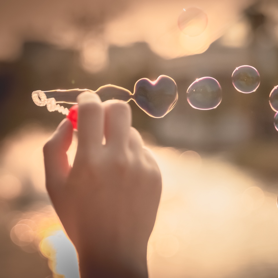 My Heart Bubbles at the sky, sunset,Love in the summer sun with bubble blower,romantic inflating colorful soap bubbles in park
